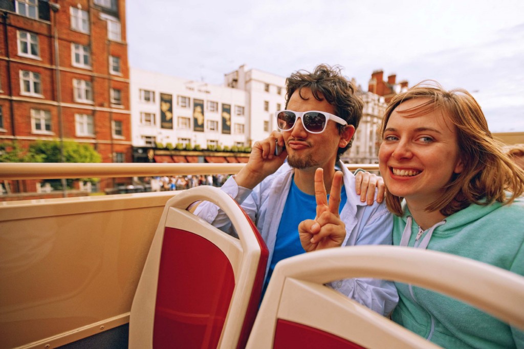 Young Couple Enjoying Double-Decker Bus ride in London